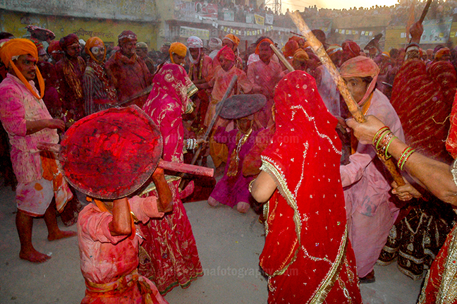 Festivals- Lathmaar Holi of Barsana (India) A man from Nandgaon protecting himself from womens of Barsana hitting on his shield with their sticks during Lathmaar Holi at Barsana. by Anil Sharma Photography