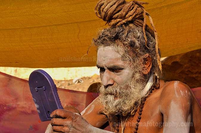 Culture- Naga Sadhu’s (India) A Naga sadhu holding mirror in his hand at Varanasi ghat. by Anil Sharma Photography